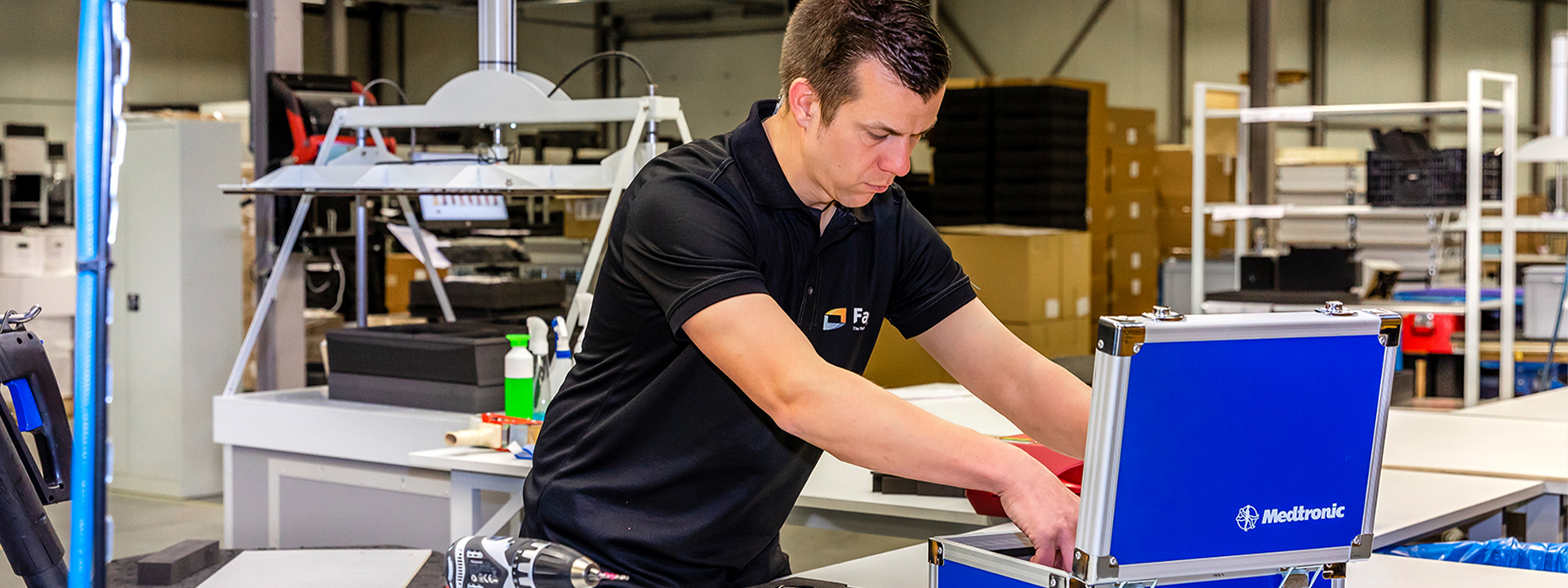 Een Faes medewerker assembleert een op maat gemaakte Medtronic verpakking in een industriële werkplaats.