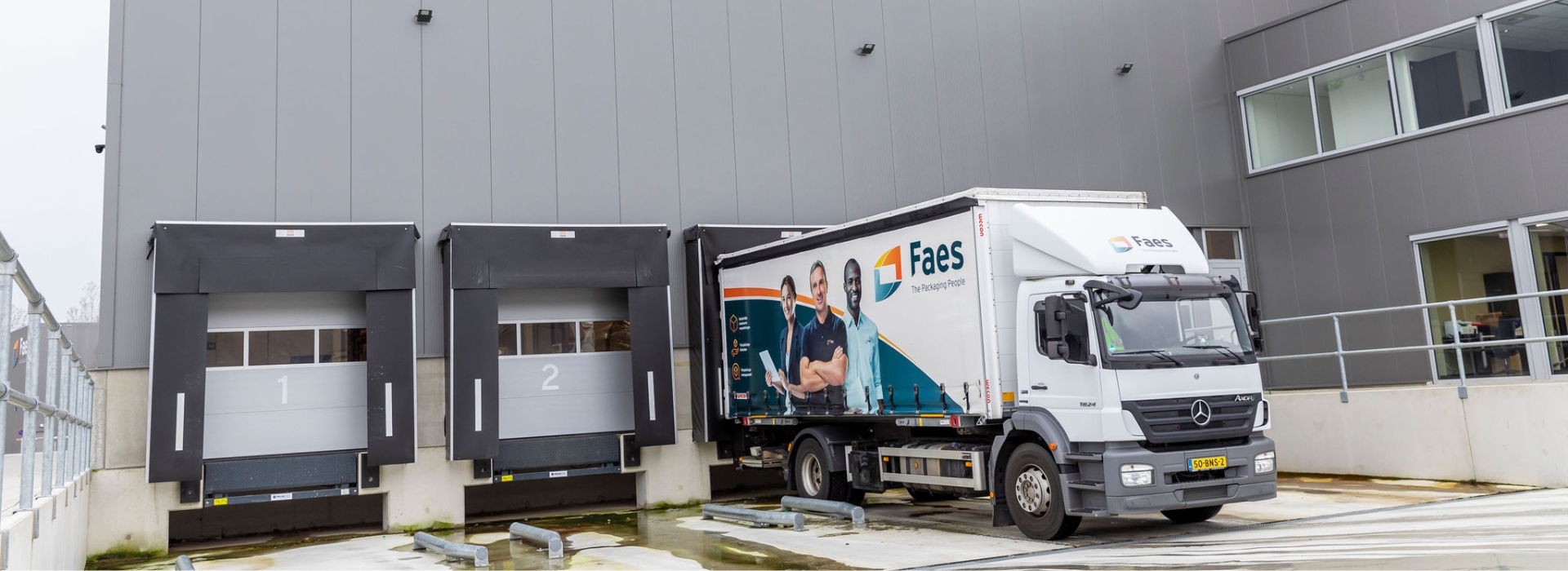 Faes vrachtwagen bij laadperron van warehouse voor logistieke distributie