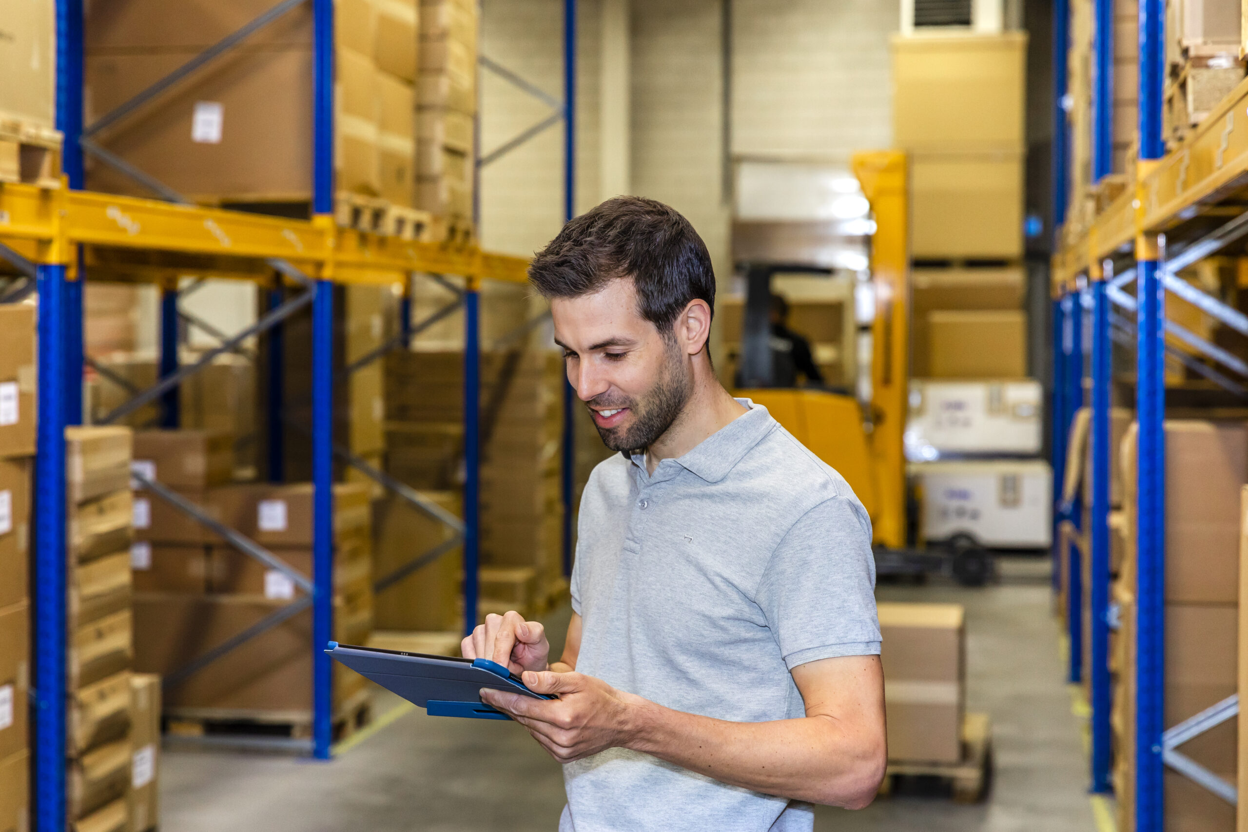 Medewerker beheert verpakkingsprocessen met tablet in magazijnomgeving
