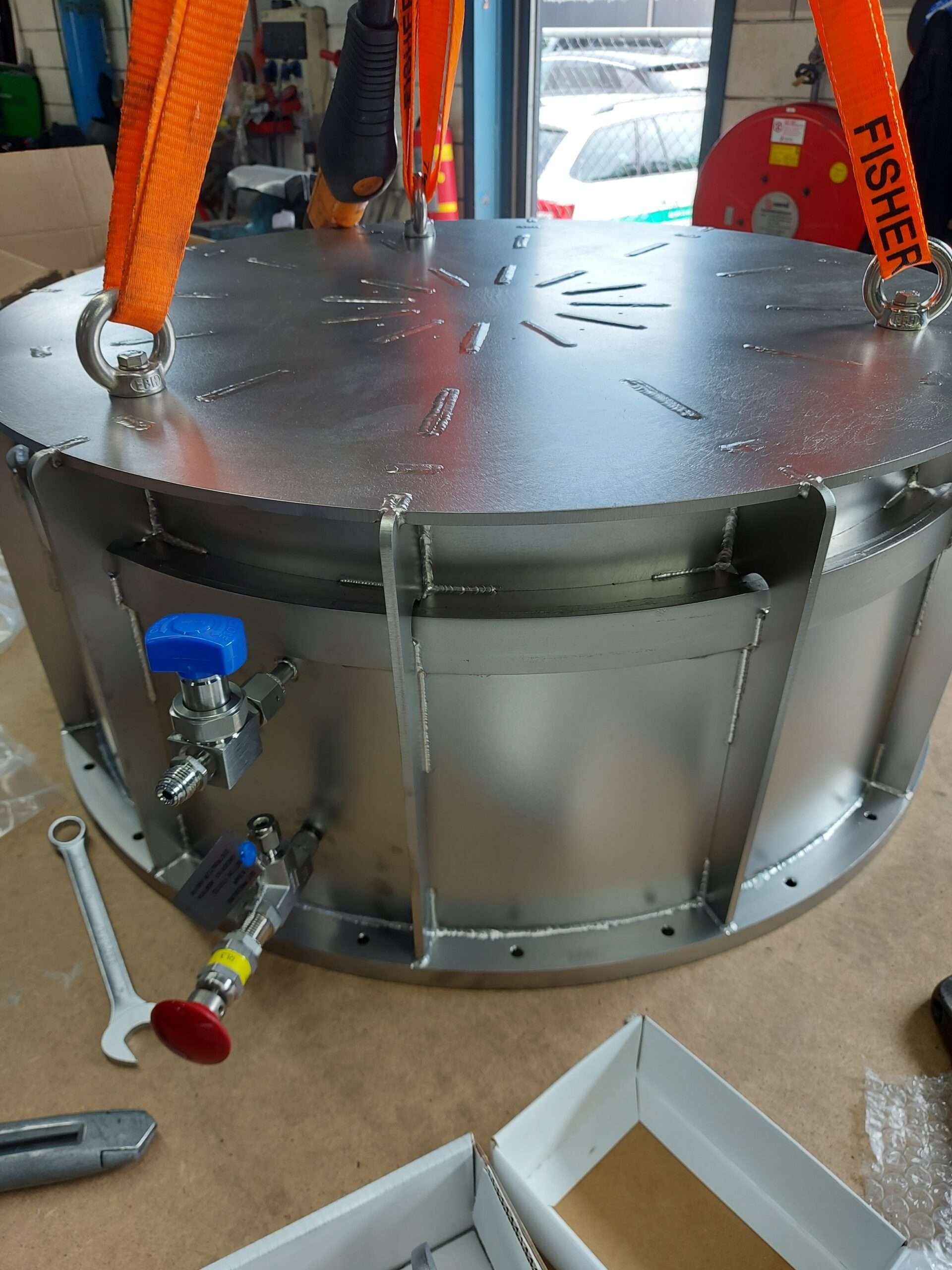Een robuuste roestvrijstalen dome, gevuld met stikstof, ontworpen voor hightech toepassingen. De dome is voorzien van diverse aansluitingen en kleppen voor gecontroleerde drukregeling, en is bevestigd aan stevige hijsbanden voor veilig transport. Ideaal voor gebruik in veeleisende omgevingen waar precisie en veiligheid essentieel zijn.