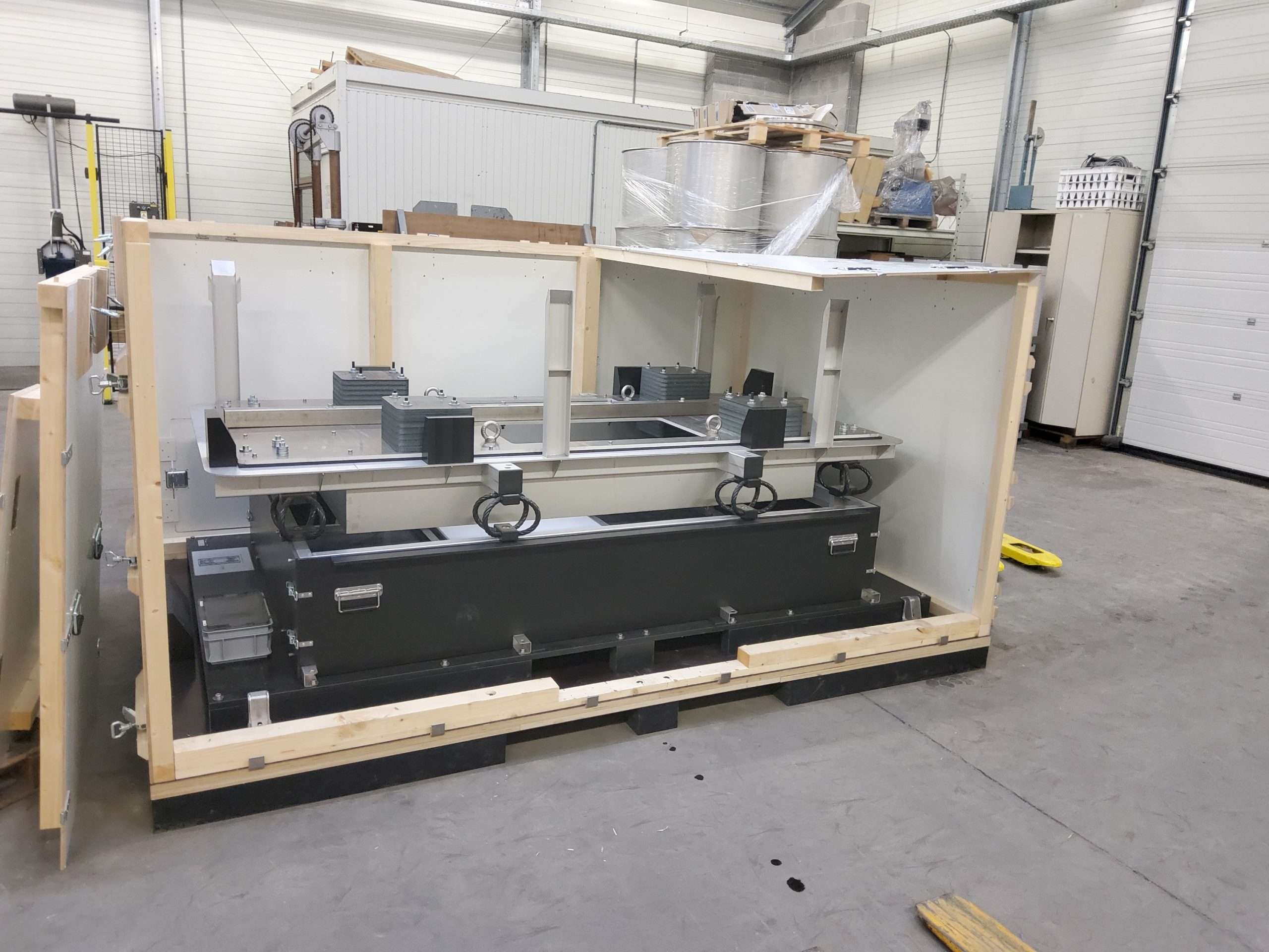Houten maatwerk kist van Faes met technische apparatuur veilig bevestigd binnenin. De kist is uitgerust met stevige metalen sluitingen en interne bevestigingsmiddelen om schade tijdens transport te voorkomen. Ideaal voor het vervoeren van gevoelige industriële componenten.