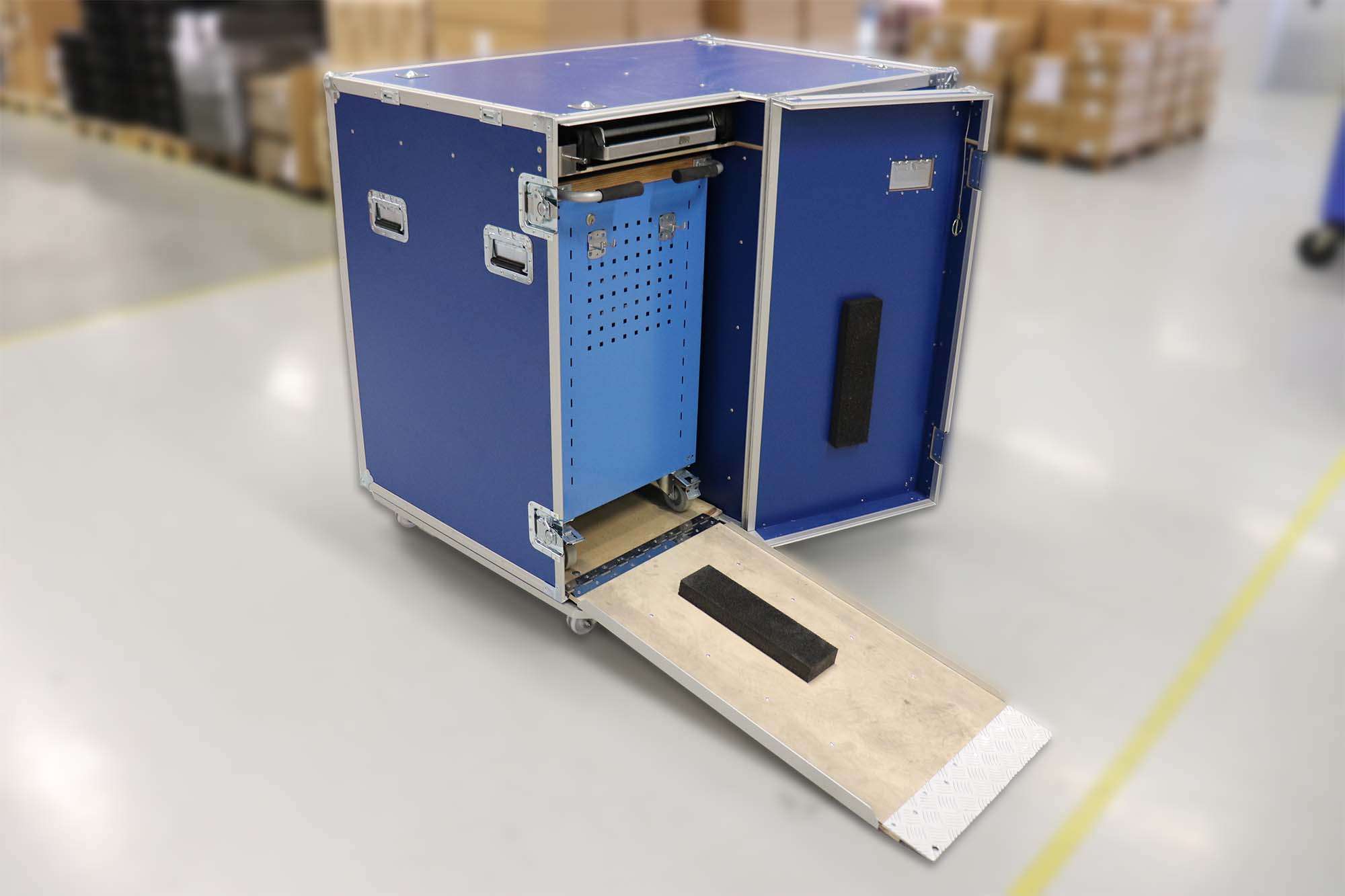Een robuuste blauwe flightcase met een uitschuifbare oprijplaat, speciaal ontworpen voor het transporteren en opbergen van mobiele werkstations of gereedschapskisten. De flightcase is voorzien van handvatten en stevige sluitingen, en de oprijplaat zorgt voor eenvoudig in- en uitladen van apparatuur. Ideaal voor toepassingen waar mobiliteit en bescherming van belang zijn.