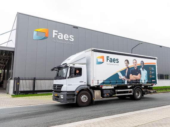 Faes vrachtwagen met bedrijfslogo vertrekt vanaf het kantoor in Reusel, gespecialiseerd in verpakkingsoplossingen.